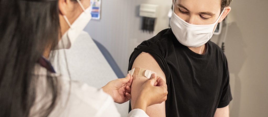 A teenager getting a vaccine representing when parents disagree over whether to vaccinate a child