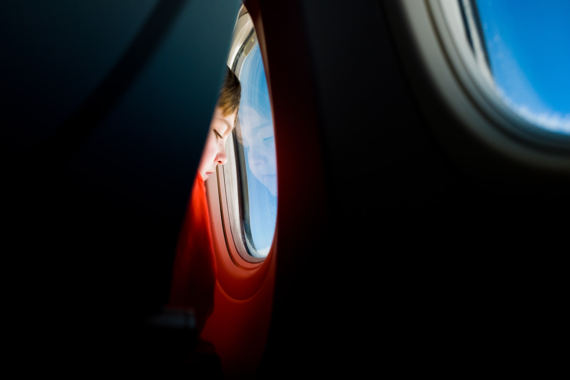 A child looking out of an airplane window representing international parental child abduction