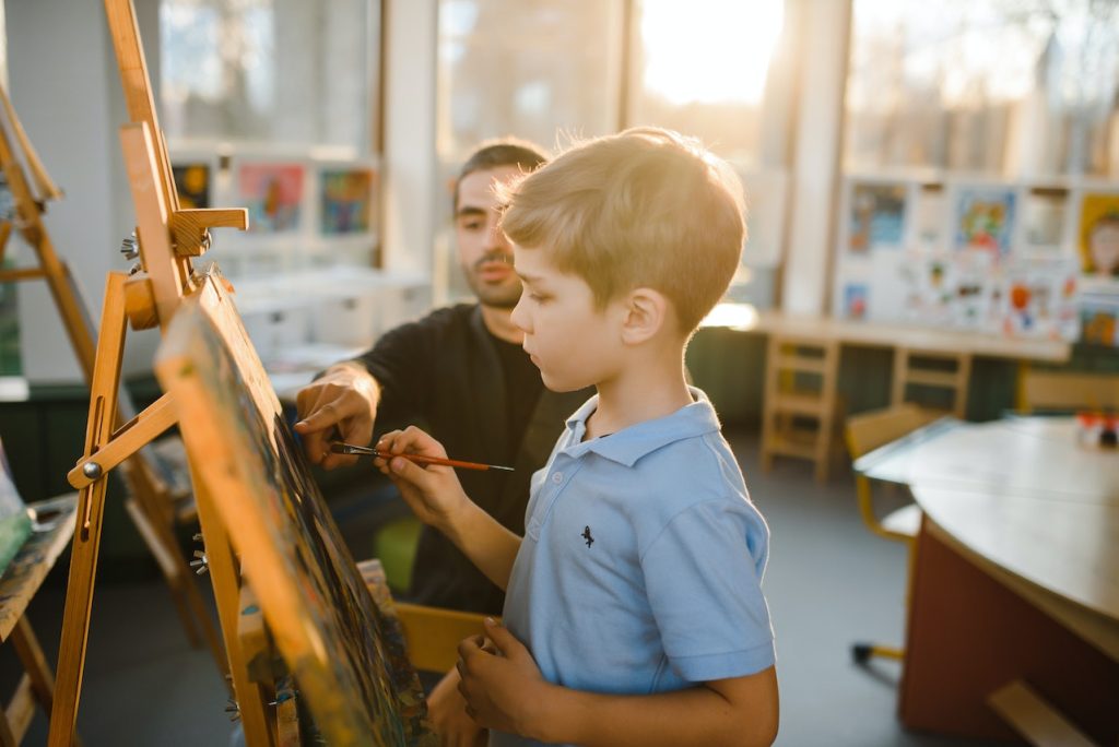 art teacher supervising a student