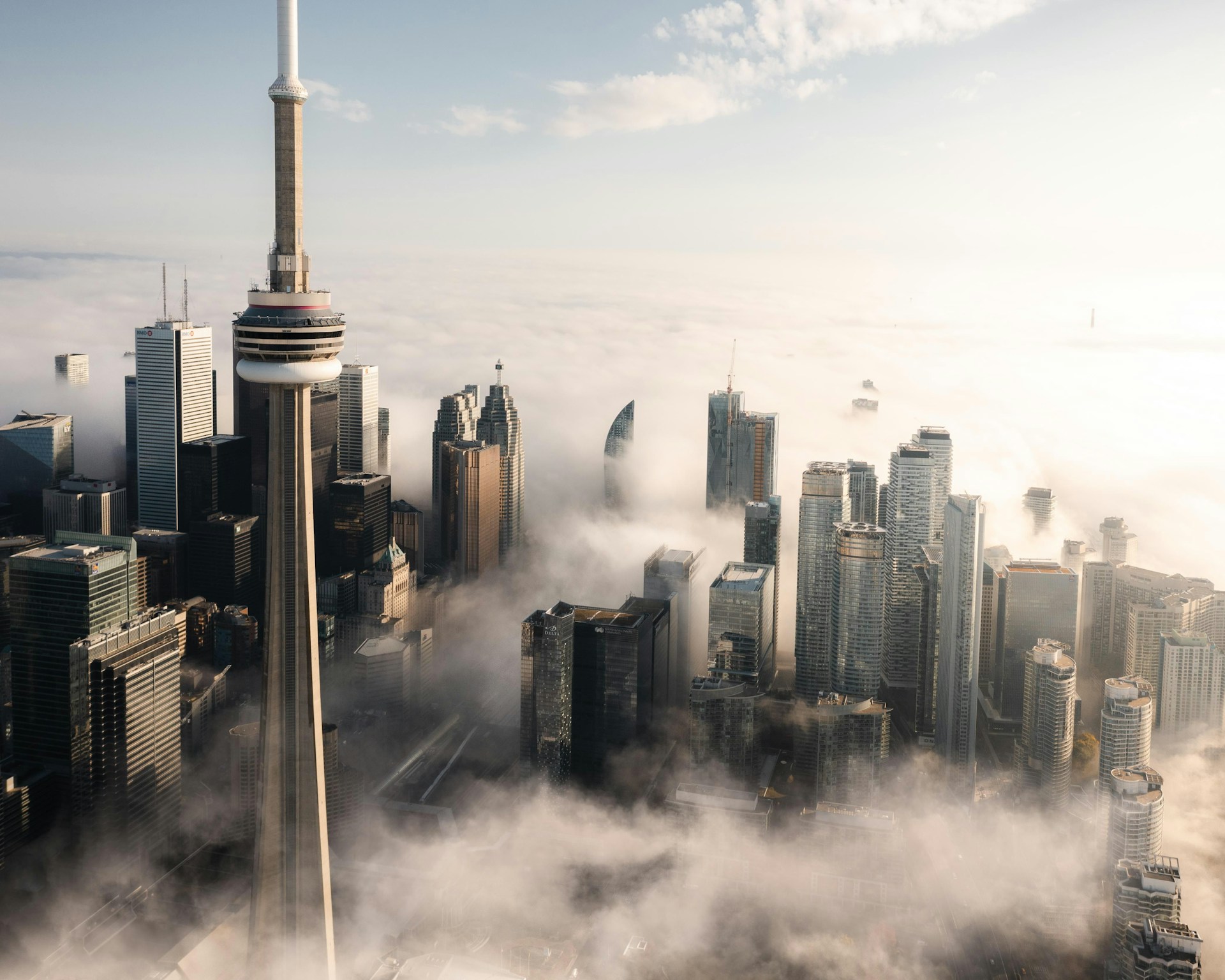 The City of Toronto with a low mist hovering between the skycrapers and the CN Tower stretching into a pale blue sky, representing Best Law Firms Canada 2027